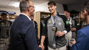 Merz gratuliert deutschen Handballern in der Kabine